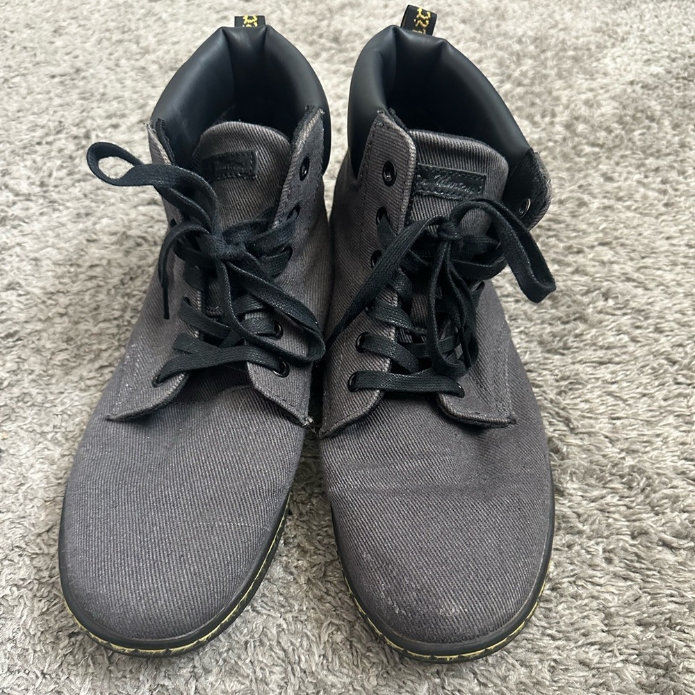 Dr Martens high top grey shoes with black bottom.